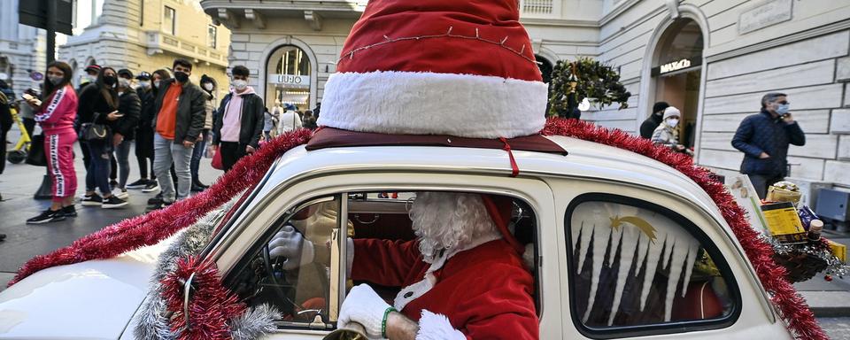 Dimanche 13 décembre: un homme habillé en Père Noël circule en Fiat 500 dans une rue du centre de Rome. [Keystone - Riccardo Antimiani]