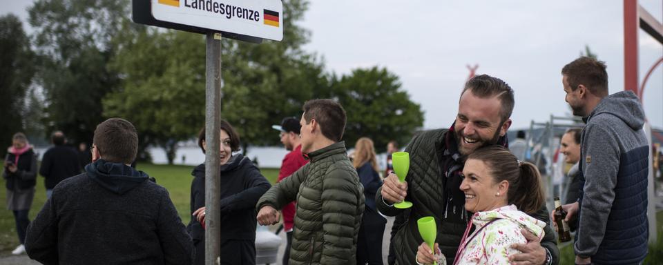 A Kreuzlingen en Thurgovie, la barrière qui séparait la Suisse de l'Allemagne est en train d'être démontée: les gens se retrouvent, le 15 mai 2020. [Keystone - Gian Ehrenzeller]