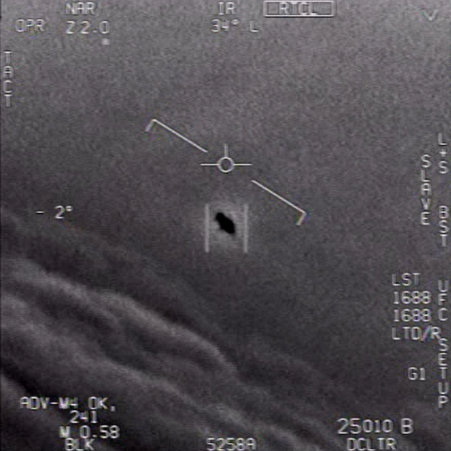 En noir au centre de l'image, un objet volant non-identifié (OVNI) filmé par un pilote de chasse américain. [Naval Air Systems Command FOIA - Capture d'écran]