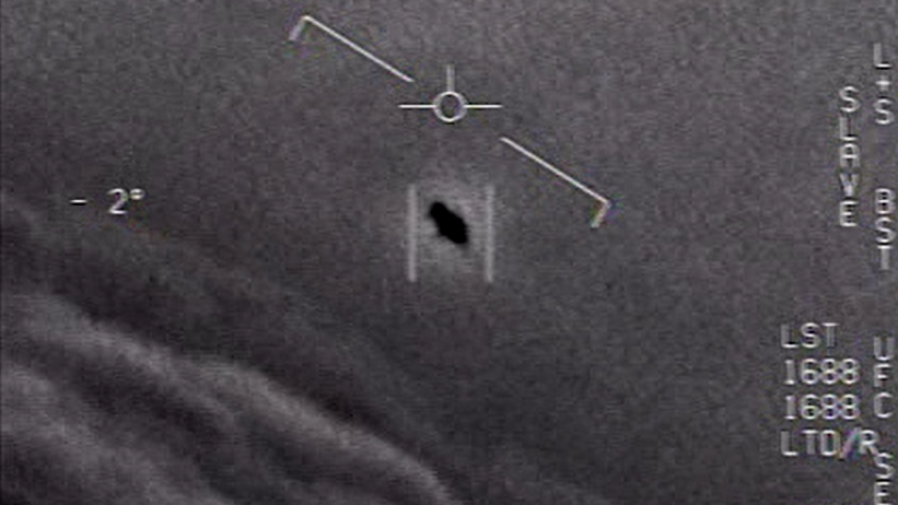 En noir au centre de l'image, un objet volant non-identifié (OVNI) filmé par un pilote de chasse américain. [Naval Air Systems Command FOIA - Capture d'écran]