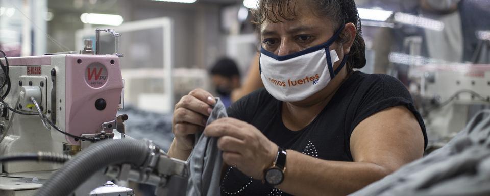 Une ouvrière porte le masque dans une fabrique de textile au Guatemala, le 10 juillet 2020. [Keystone - Moises Castillo]