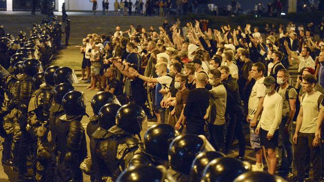 Des manifestants face à la police à Minsk, en Biélorussie, après les élections présidentielles. [AP/Keystone]