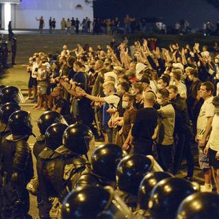 Des manifestants face à la police à Minsk, en Biélorussie, après les élections présidentielles. [AP/Keystone]