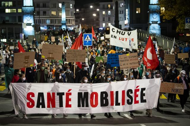 Environ 600 soignants vaudois se sont réunis  en début de soirée mercredi sous les fenêtres de la direction du CHUV à Lausanne avant de défiler à travers la ville, pour dénoncer les conditions de travail précaires du personnel de santé face au coronavirus. [keystone - jean-christophe bott]