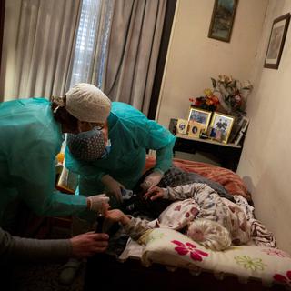 Des infirmiers s'occupent d'une patiente durant la pandémie de coronavirus à Barcelone, en Espagne. [EPA/Keystone - Enric Fontcuberta]