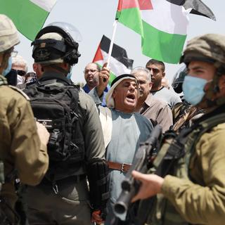 Des manifestants palestiniens face à des soldats israéliens, près du checkpoint militaire de Jabara, à Tulkarem, dans le nord de la Cisjordanie, le 5 juin 2020. [AFP/Anadolu Agency - Issam Rimawi]