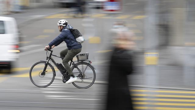 Un conducteur de vélo électrique sur le Limmatquai à Zurich. [Keystone - Gaëtan Bally]