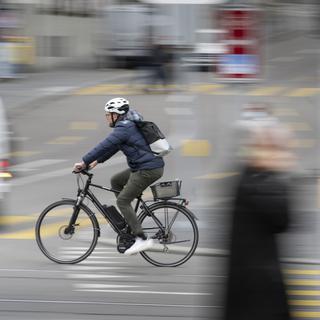 Un conducteur de vélo électrique sur le Limmatquai à Zurich. [Keystone - Gaëtan Bally]