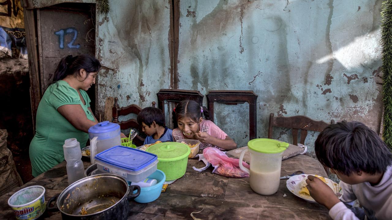 Trois enfants d'une famille de Lima, au Pérou, se nourrissent d'un plat fourni par une association caritative, le 8 juin 2020. [AP/Keystone - Rodrigo Abd]