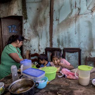 Trois enfants d'une famille de Lima, au Pérou, se nourrissent d'un plat fourni par une association caritative, le 8 juin 2020. [AP/Keystone - Rodrigo Abd]