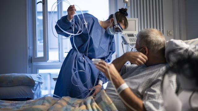 Une soignante et un patient Covid à l'hôpital universitaire de Zurich, le 19 novembre 2020. [Keystone - Christian Beutler]