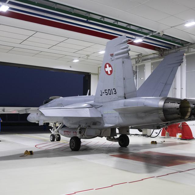 Un F/A-18 prêt à un décollage d'alarme dans un hangar de la base de Payerne. [Keystone - Peter Klaunzer]