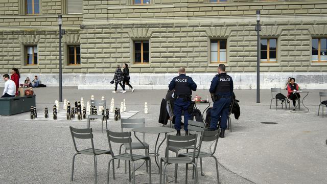 Deux policiers discutent avec des passants à Berne. [Keystone - Anthony Anex]