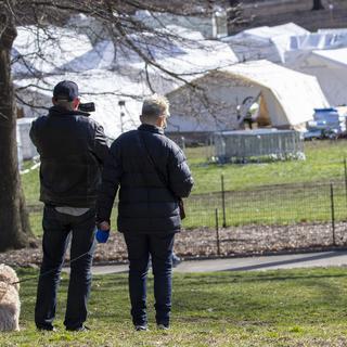Un couple observe l'installation d'un l'hôpital provisoire dans Central Park. [Keystone/AP Photo - Mary Altaffer]
