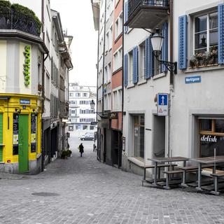 Des cafés et des commerces fermés à cause du coronavirus dans une rue de Zurich le 21 mars 2020. [Keystone - Alexandra Wey]