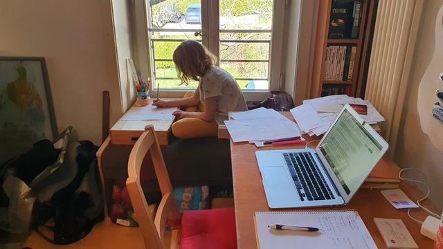 Eileen travaille à la maison, sur un bureau improvisé, à côté de celui de sa maman. [Magaly Grimaitre]