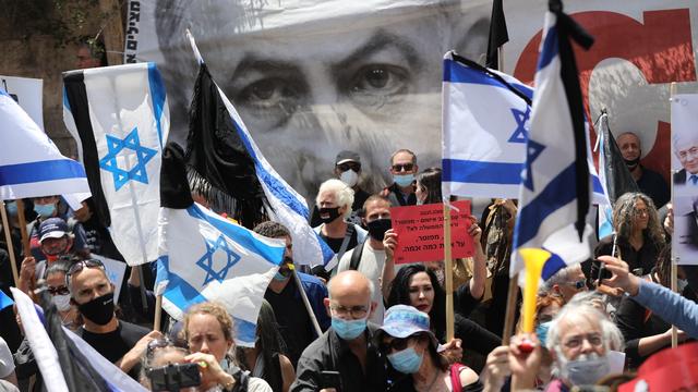 Des manifestations pro et anti-Netanyahu ont eu lieu en marge de son procès à Israël. [Keystone - Abir Sultan / EPA]