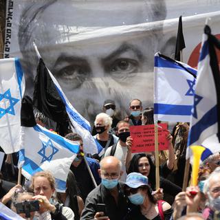 Des manifestations pro et anti-Netanyahu ont eu lieu en marge de son procès à Israël. [Keystone - Abir Sultan / EPA]