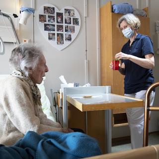 Une aide-soignante et une résidente d'un EMS à Château-d'Oex, le 20 avril 2020. [Keystone - Laurent Gillieron]