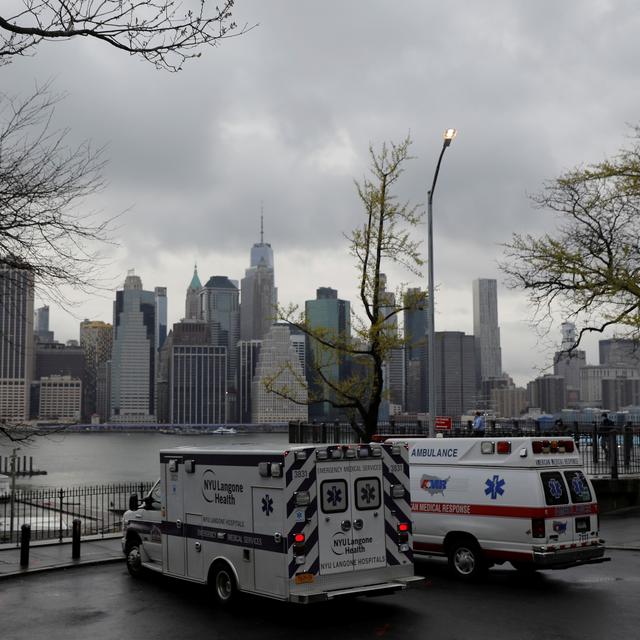 Des ambulances parquées à Brooklyn, à New York, en face des buildings du quartier de Manhattan. [Reuters - Andrew Kelly]