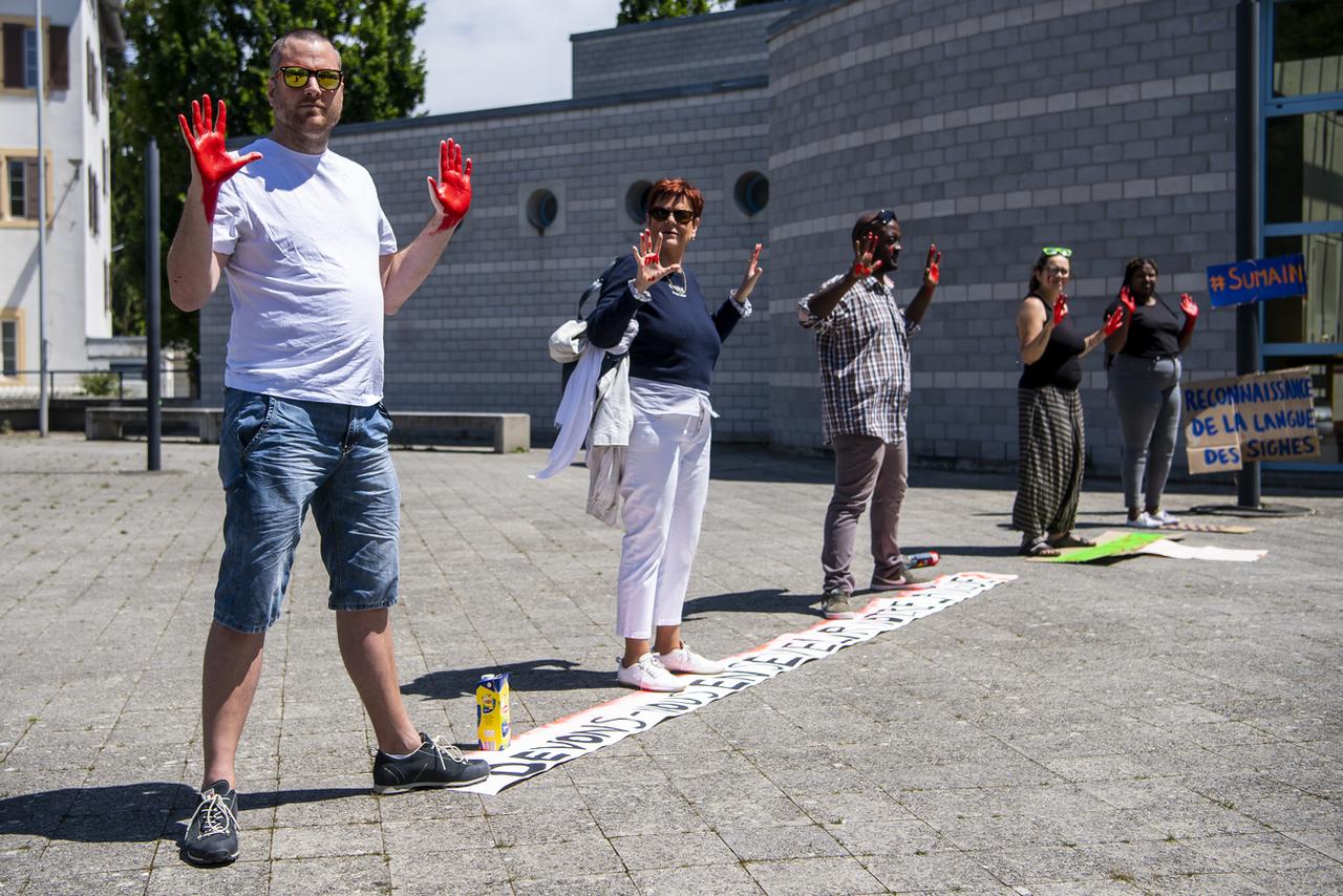 Des membres de l'Association des sourds vaudois ont manifesté devant l'entrée du bâtiment où siège provisoirement le Grand Conseil vaudois à Yverdon [Keystone - Jean-Christophe Bott]