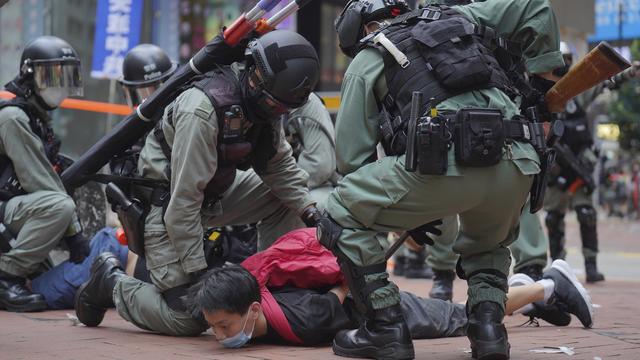 Des policiers anti-émeute maintiennent au sol un manifestant pro-démocratie, le 24 mai 2020 à Hong Kong. [AP/Keystone - Vincent Yu]