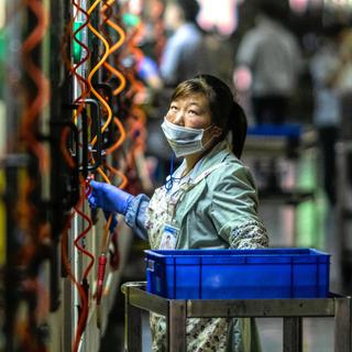Une employée de l'usine Everwin, en Chine, qui produit des éléments pour Apple, Samsung, etc... [Keystone - EPA-EFE / Aleksandar Plavevski]
