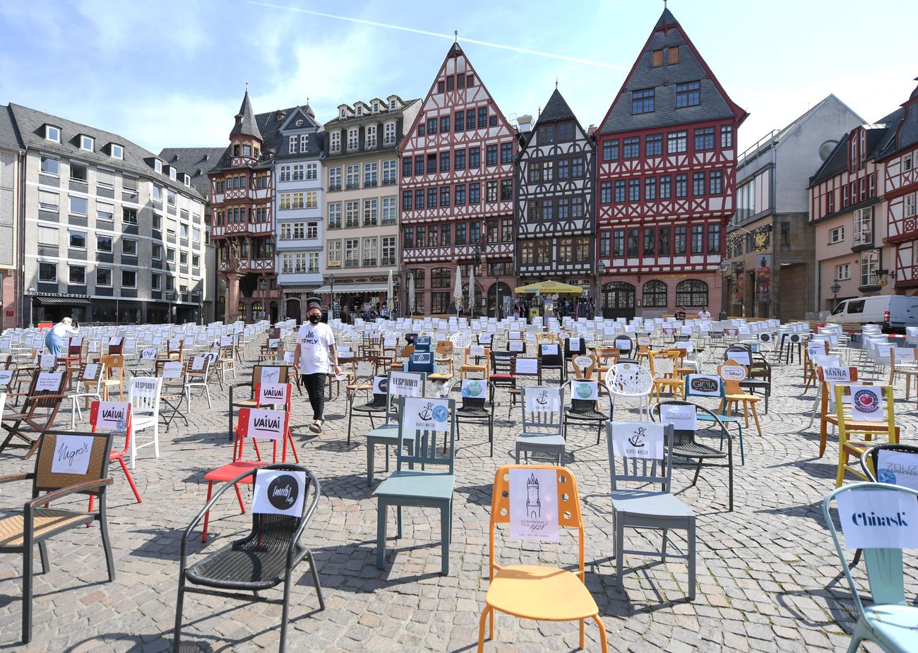 A Frankfort, la place Römerberg a été envahie par les chaises des restaurants obligés de fermer, en signe de protestation. [Keystone - DPA/Arne Dedert]