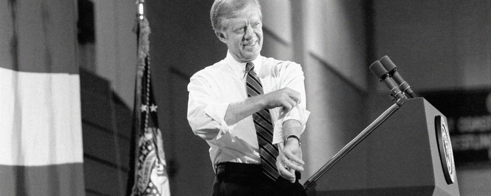 Le président des Etats-Unis Jimmy Carter retrousse ses manches lors d'un discours de campagne à Hempstead (New York), le 16 octobre 1980. [Keystone/AP - Wilson]