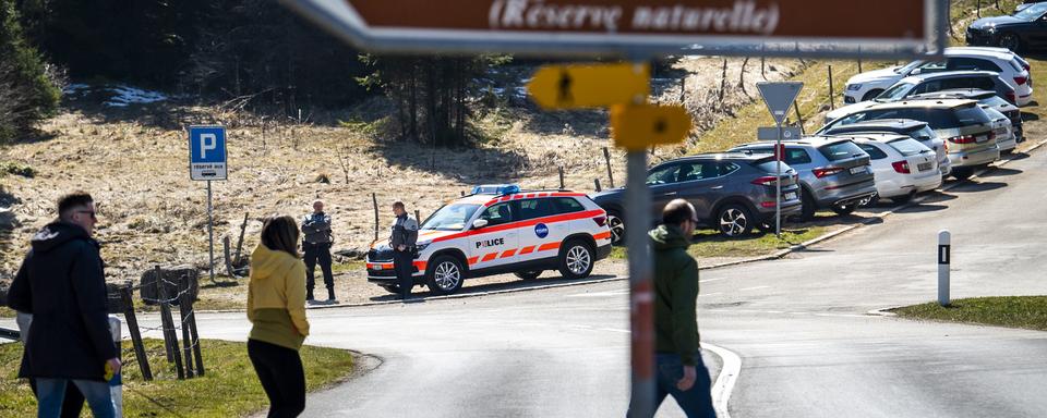 Une patrouille de police contrôle l'accès à l'étang de la Gruère. [Keystone - Jean-Christophe Bott]