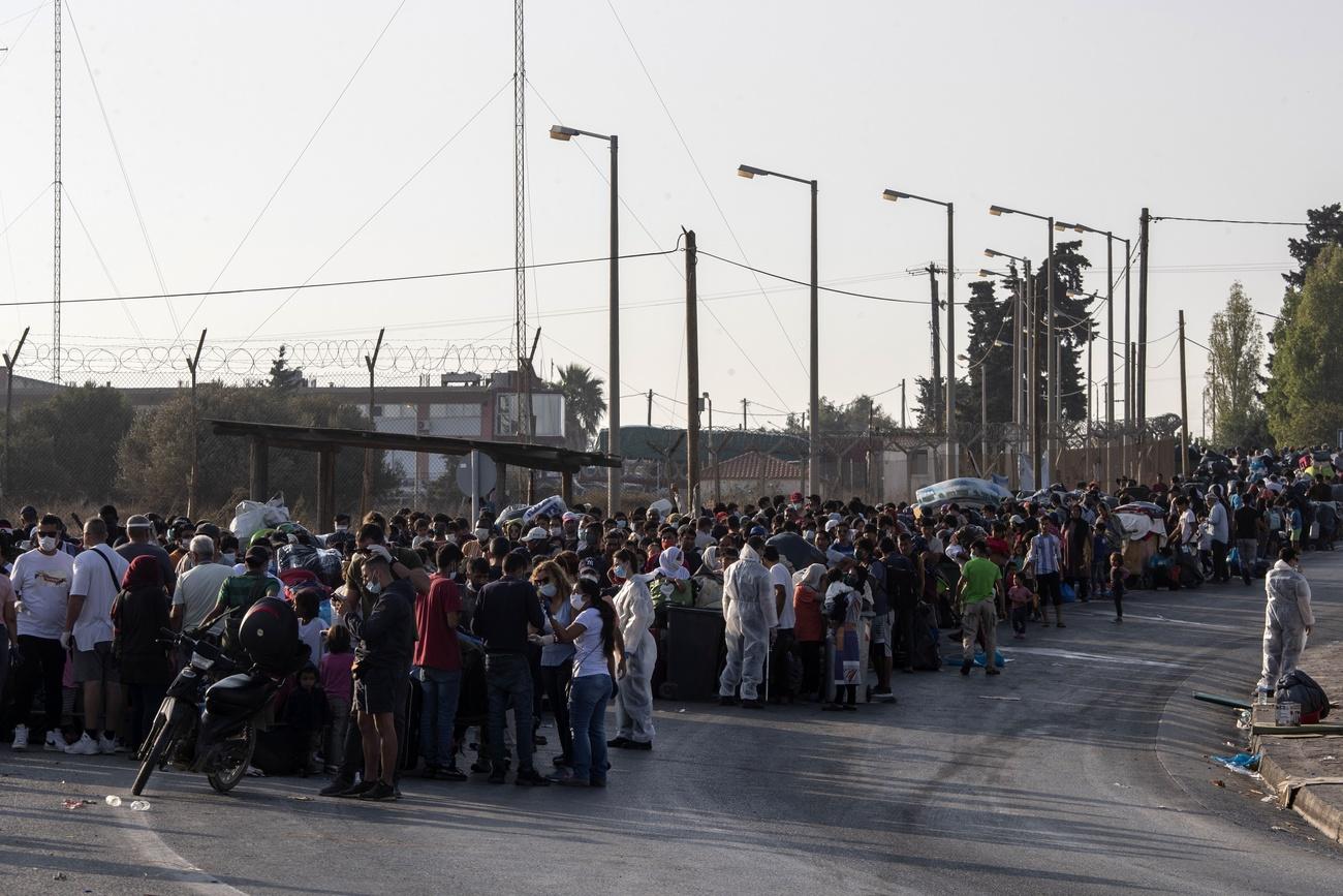 Des milliers de migrants de Moria faisaient la queue vendredi à l'entrée du nouveau camp. [Keystone/AP - Petros Giannakouris]