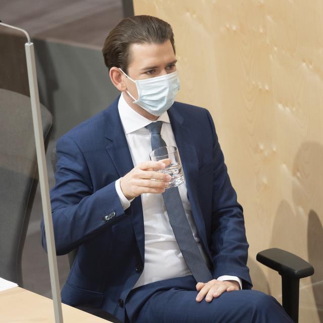 Le Chancelier autrichien Sebastian Kurz porte un masque lors d'une session parlementaire dans le palais Hofburg, à Vienne, le 3 avril 2020. [Keystone - Christian Bruna]