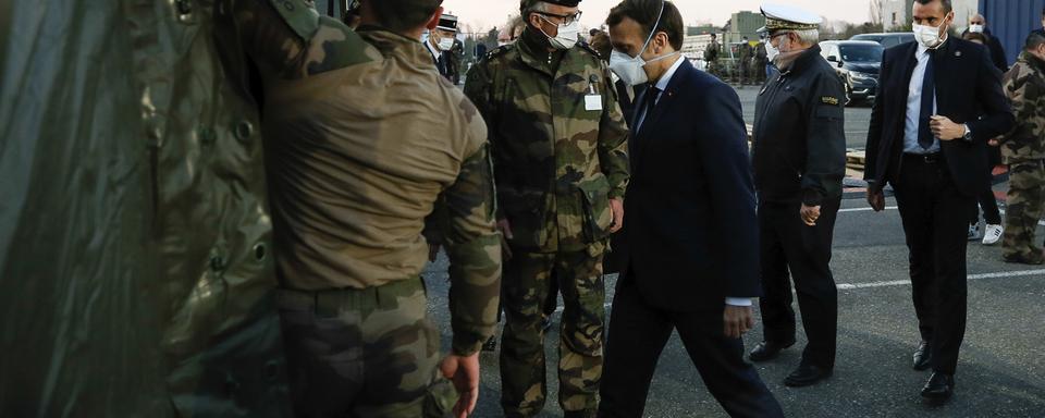 25 mars: le président français Emmanuel Macron masqué lors de sa visite de l'hôpital de campagne de Mulhouse. [Keystone - Mathieu Cugnot]