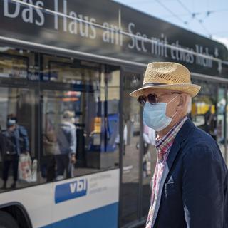 L'obligation de porter un masque dans les transports publics est en discussion. [Keystone - Urs Flueeler]