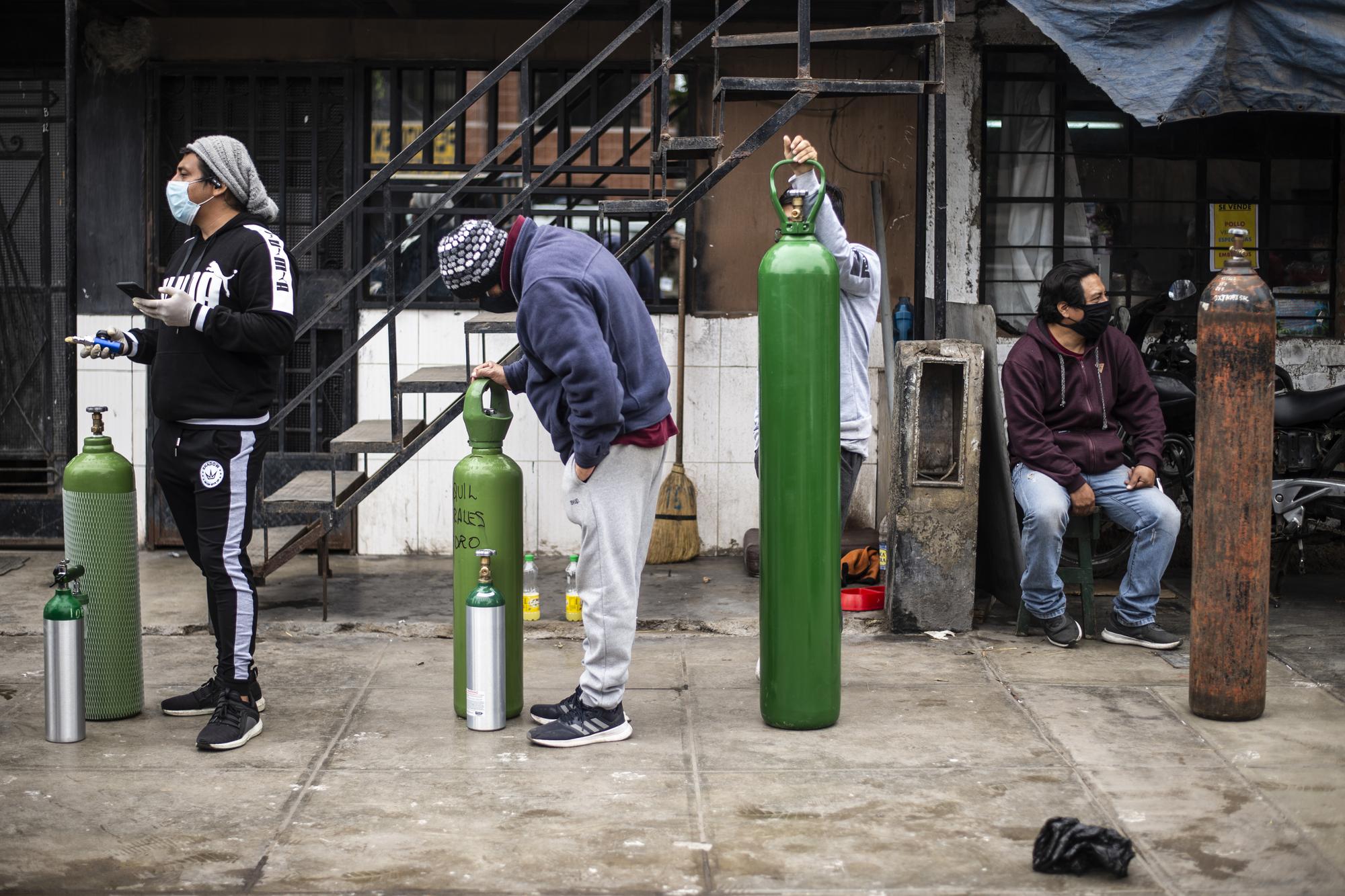 Des gens font la file pour remplir des bouteilles d'oxygène pour leurs proches atteints par la maladie du Covid-19. Callao, Pérou, le 3 juin 2020. [AFP - Ernesto Benavides]