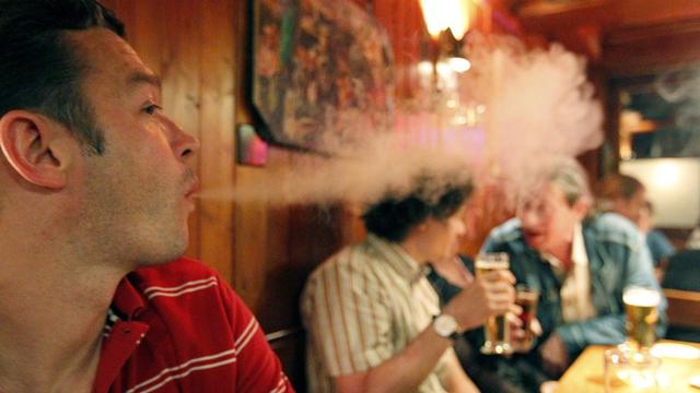 En Suisse, depuis le 1er mai 2010, les fumeurs ne peuvent plus tirer sur une cigarette dans un restaurant ou un bar. [Keystone - Urs Flueeler]