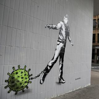 Sur un mur de la rue Bath, à Glasgow, un graffiti de l'artiste Rebel Bear a pour thème le coronavirus. Ecosse, le 3 avril 2020. [Keystone - Andrew Milligan]