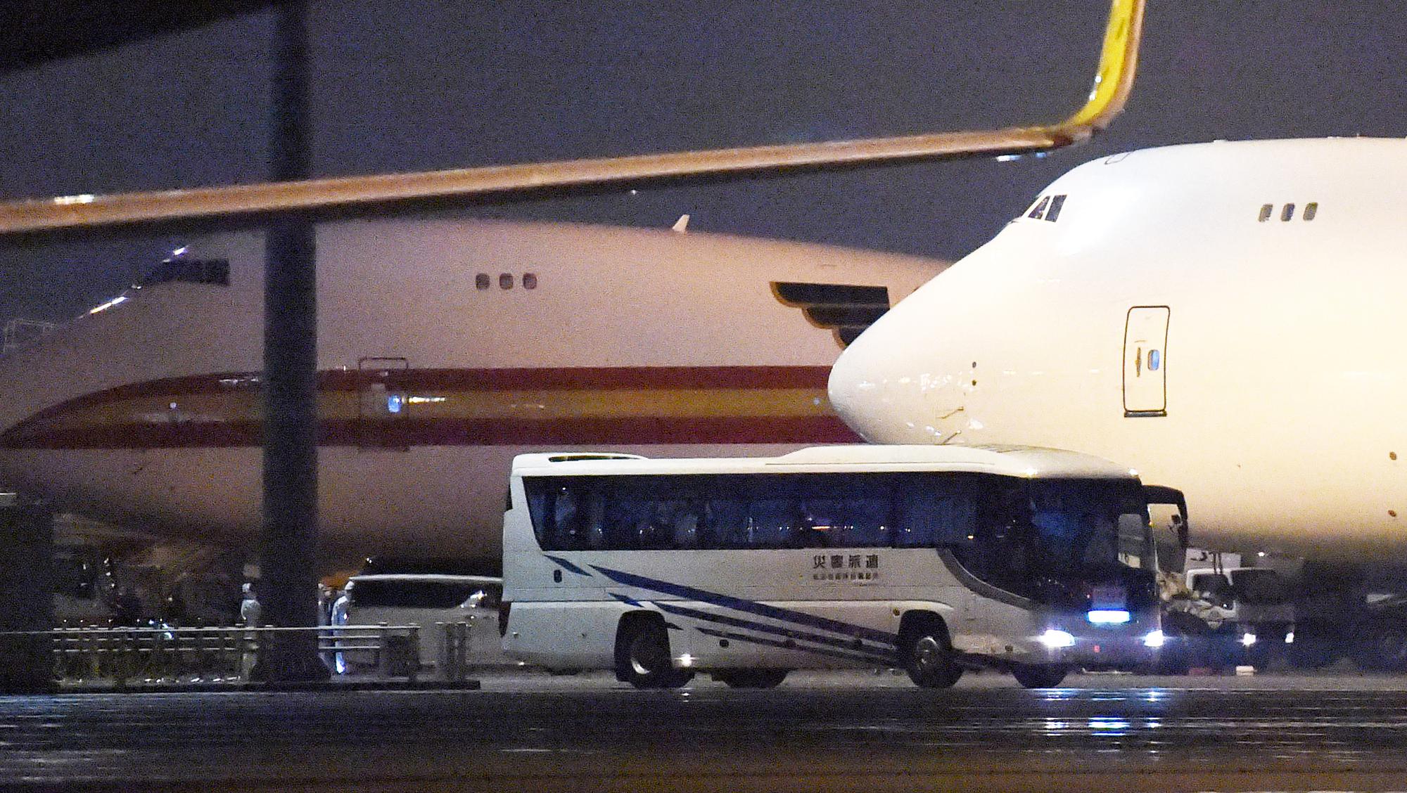 Un bus des forces japonaises arrive à l'aéroport de Tokyo. Environ 380 passagers américains du paquebot Diamond Princess ont été rapatriés vers leur pays. [The Yomiuri Shimbun - Miho Ikeya]