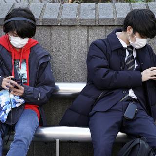 De jeunes hommes portant des masques dans le district de Shibuya, à Tokyo, le 3 février 2020. [Keystone - Franck Robichon / EPA]