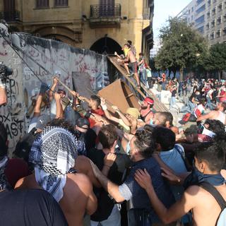 Des manifestants anti-gouvernement attaquent un mur de protection vers le Parlement libanais. [Keystone - EPA / Ibrahim Dirani Dar al Mussawir]