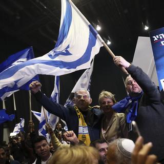 Benjamin Netanyahu au milieu de ses supporters, portant un masque à son effigie. [AP/Keystone - Oded Balilty]