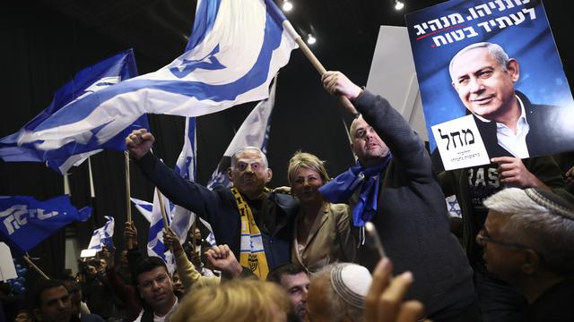 Benjamin Netanyahu au milieu de ses supporters, portant un masque à son effigie. [AP/Keystone - Oded Balilty]