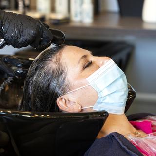Comme à l'issue de la première vague, les plans de protection restent strictes dans les salons de coiffure, d'esthétisme et autres studios de tatouage, tous autorisés à rouvrir dès ce samedi à Genève. [keystone - Alexandra Wey]