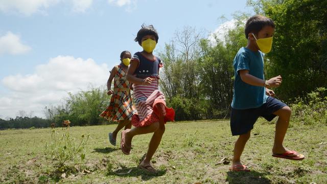 Des enfants portant des masques jouent, le 20 avril 2020 dans le district d'Assam en Inde. [EPA/Keystone]