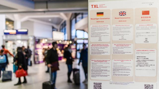 Des affiches renseignent les voyageurs sur les mesures de prévention en vigueur à l'aéroport de Berlin-Tegel [Keystone/EPA - Clemens Bilan]