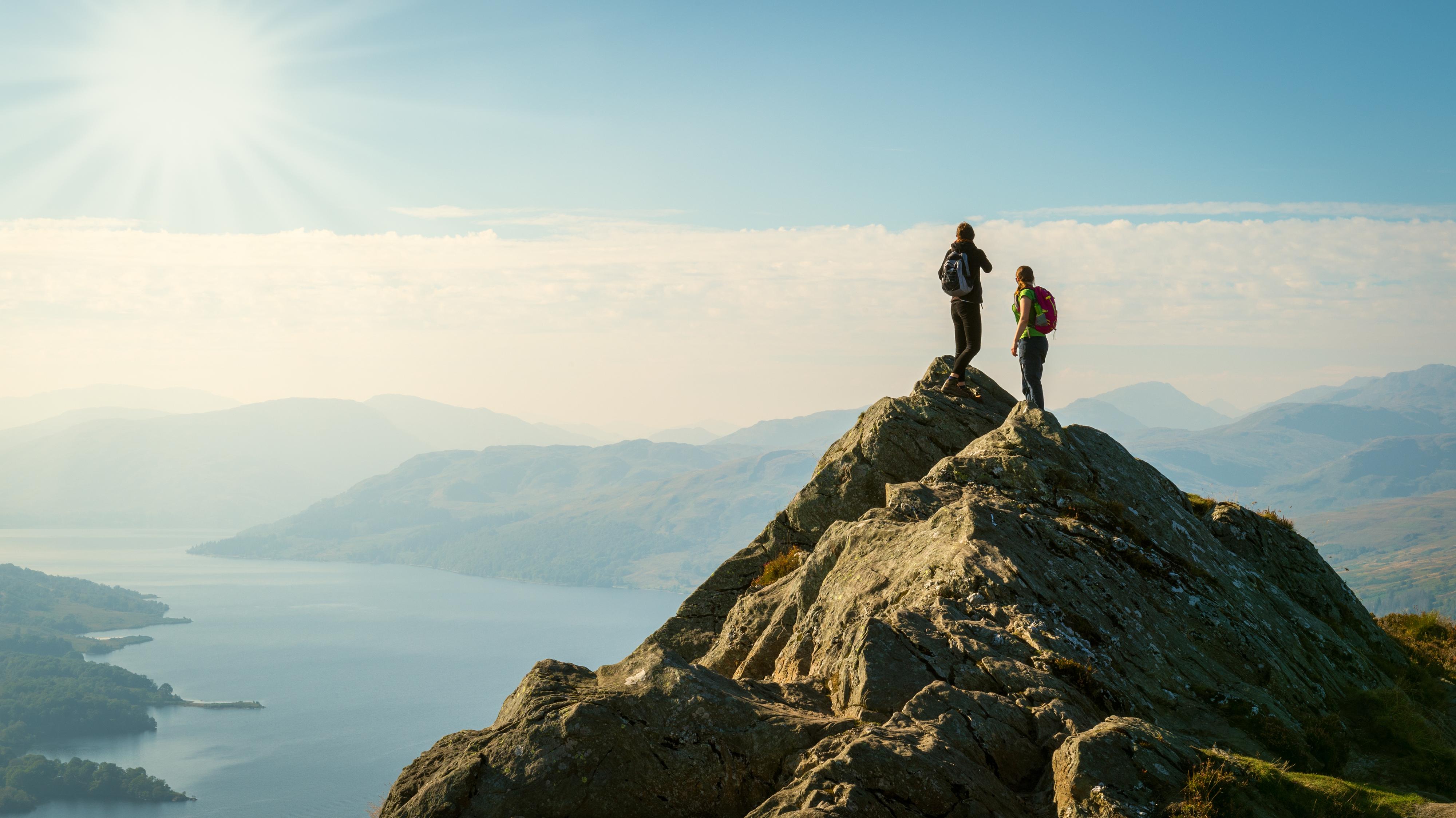 Deux randonneurs au sommet de la montagne en profitant de la vallée. Highlands, Ecosse, Royaume-Uni. [depositphotos.com - Andrea Obzerova]