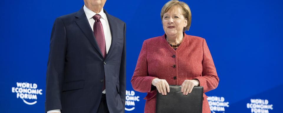 Angela Merkel en compagnie du fondateur du WEF Klaus Schwab. [Keystone - Gian Ehrenzeller]