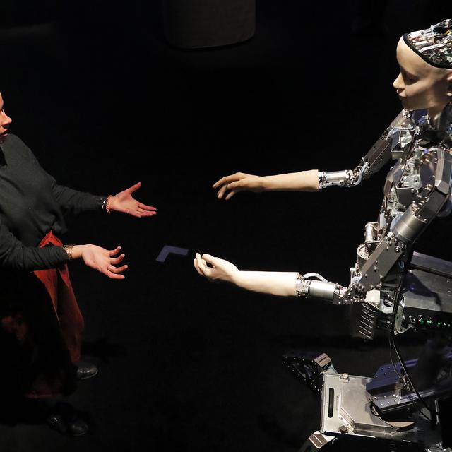 Une femme interagit avec un robot [Keystone - Frank Augstein]