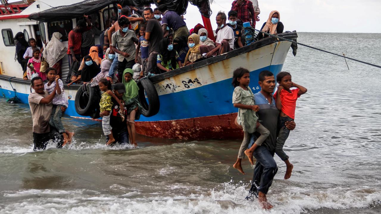 Des locaux qui aident des réfugiés rohingyas au nord de la côte d'Aceh à évacuer du bateau [REUTERS - Antara Foto/Rahmad]
