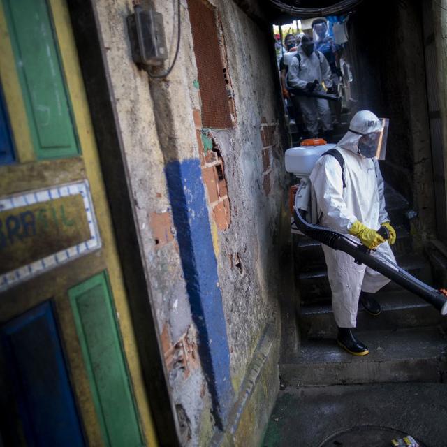 Un volontaire désinfecte une rue de Rio de Janeiro. [AFP - Mauro Pimentel]